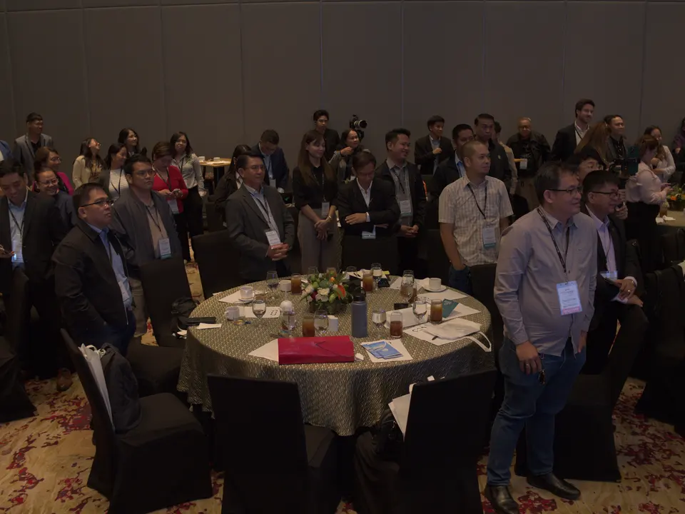 Conference delegates standing together beside banquet tables