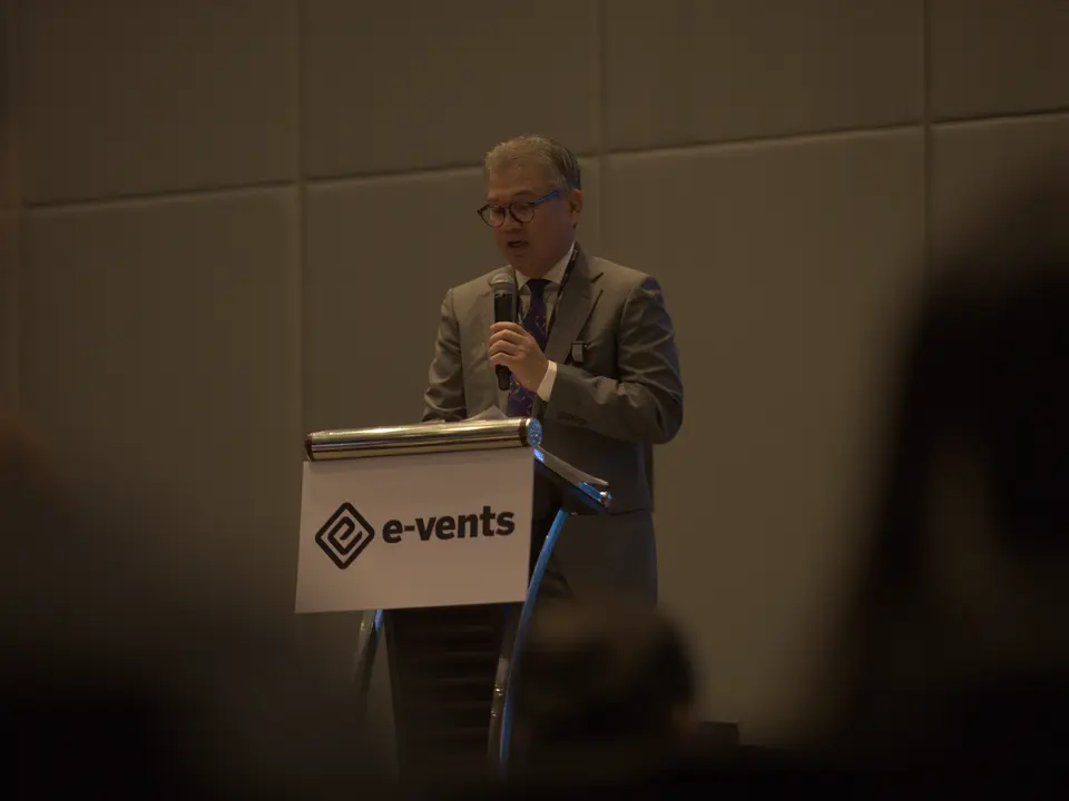 Speaker delivering remarks from the conference lectern