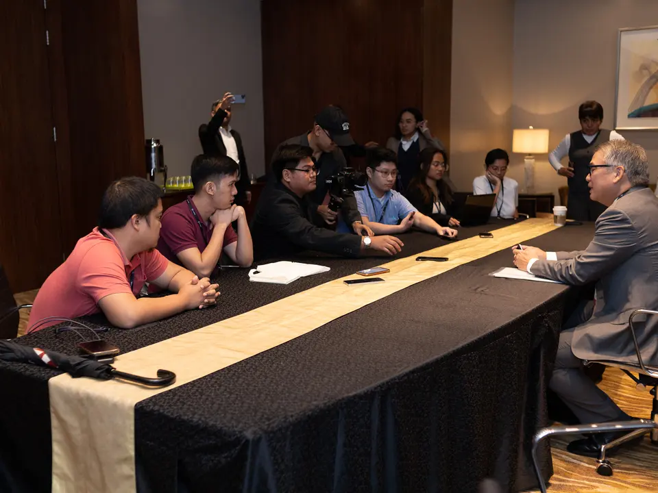 Attendees speaking with a conference representative at a registration table