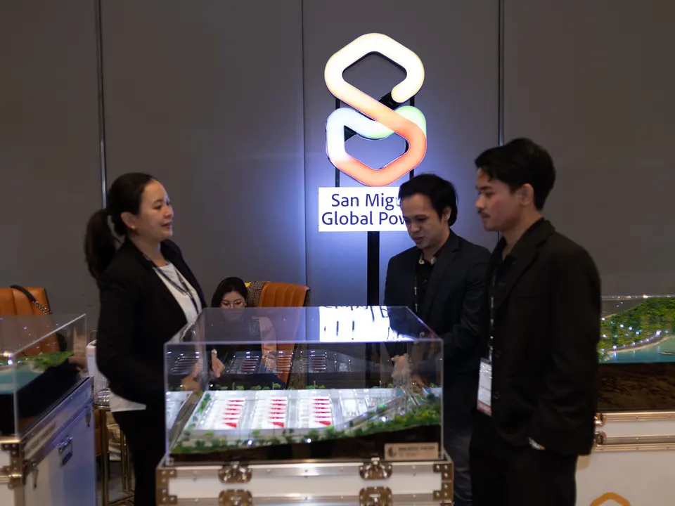 Exhibitors discussing equipment at a trade show booth