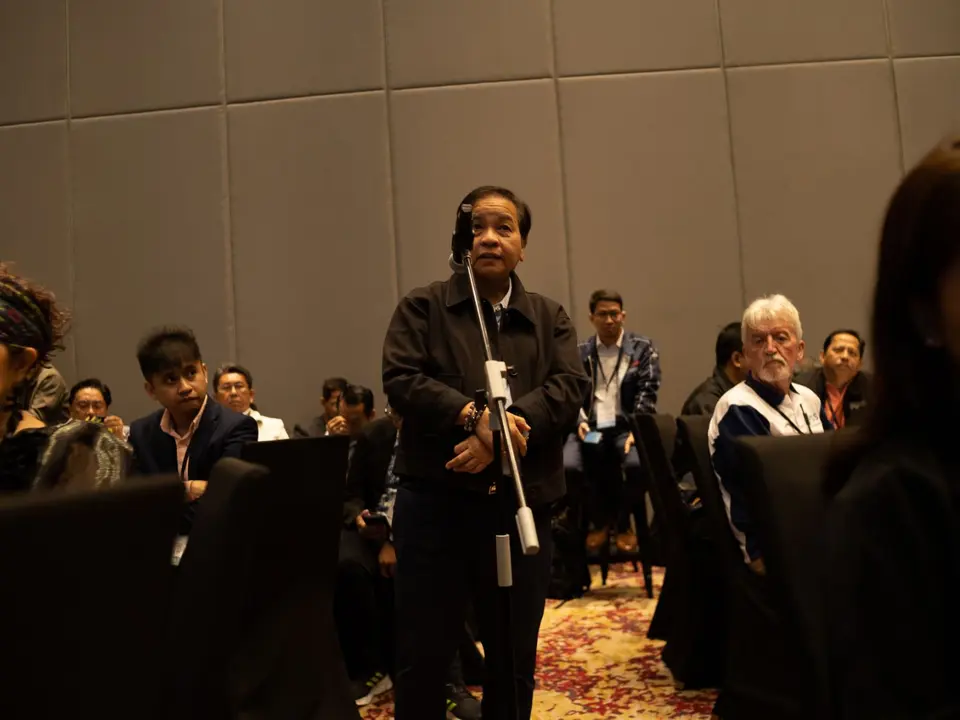 Woman asking a question during a renewable energy conference session