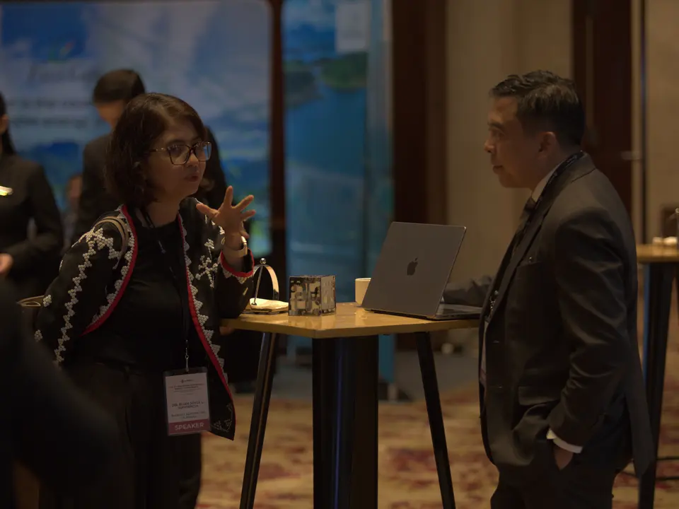 Conference delegates in conversation beside an exhibitor table