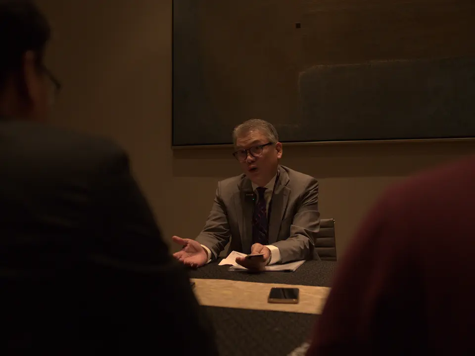 Conference attendee asking a question during a discussion session